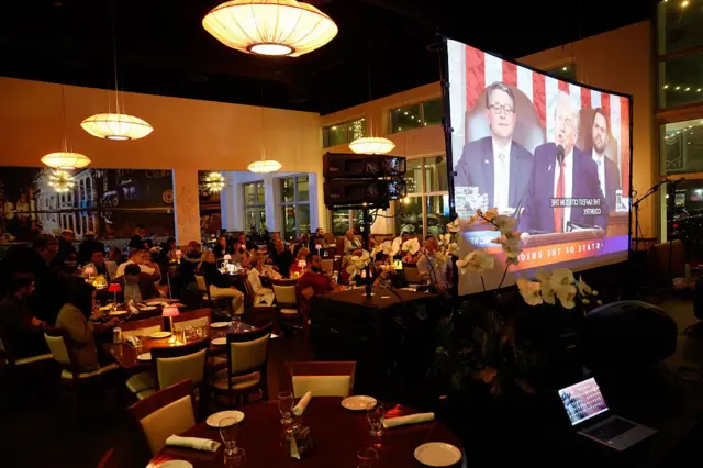 Участники мероприятия, организованного Республиканской партией округа Майами-Дейд в Дорале, штат Флорида, США, во вторник, 24 февраля 2026 года, наблюдают за выступлением президента США Дональда Трампа