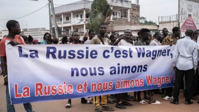 Manifestantes carregam faixas em Bangui, em 22 de março de 2023, durante uma marcha em apoio à presença da Rússia e da China na República Centro-Africana