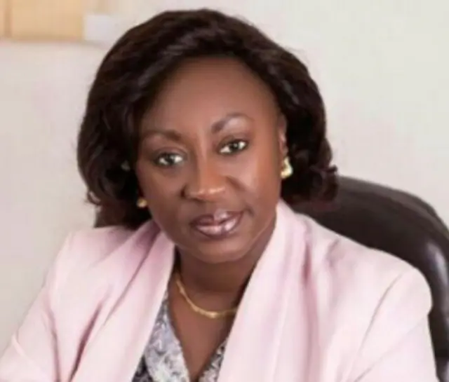 Patricia Poku-Diaby en costume rose, elle regarde dans la caméra.