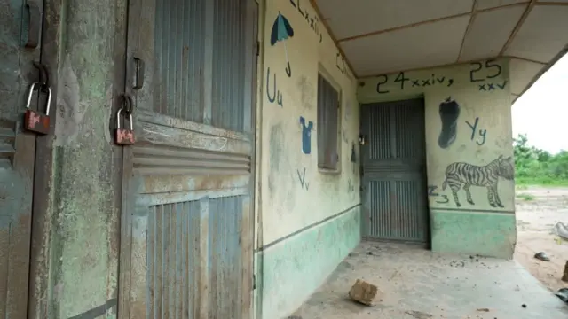 La façade d'une école, portes closes et cadenassées. Des dessins d'enfants, dont un zèbre, ornent les murs.