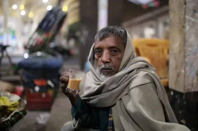 শীতে চা হাতে একজন বয়স্ক মানুষ 