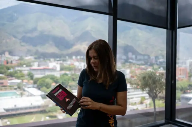 La periodista de investigación venezolana Ronna Rísquez con su libro sobre el Tren de Aragua en la mano, en Caracas, el 22 de marzo de 2023. (Photo by AFP stringer / AFP) (Photo by AFP STRINGER/AFP via Getty Images)