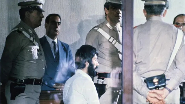 Mehmet Ali Ağca, 1981'de İtalya'daki bir yargılama sırasında. Çevresinde İtalyan polisleri görülüyor.