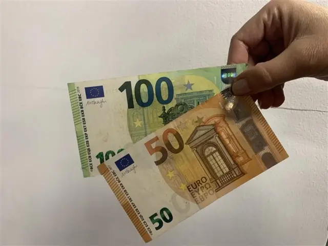 Ruka drži novčanice od 100 i 50 evra