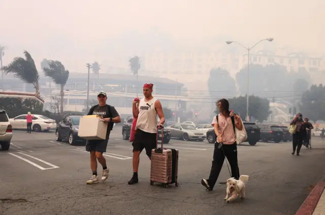 Tri osobe nose stvari i vuku kuče