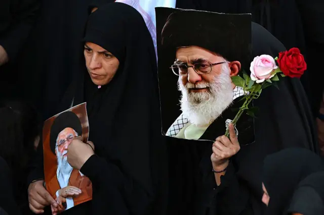 Para pelayat membawa bunga dan potret Ali Khamenei, menjelang prosesi pemakaman dirinya dan sejumlah anggota keluarganya, sebelum dimakamkan di Kompleks Makam Imam Reza di Mashhad pada 9 Juli 2026.