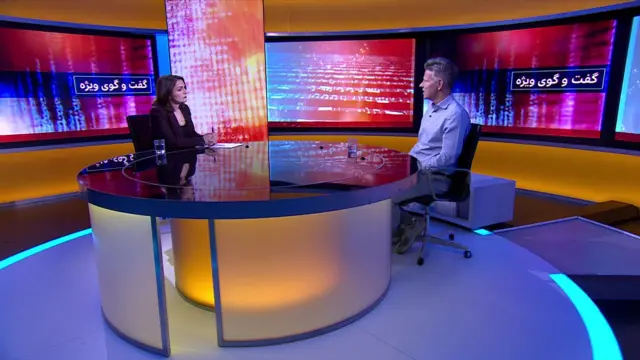 جورج لاوسن در استودیوی تلویزیونی برنامه گفت‌وگوی ویژه، مقابل مجری نشسته و در حال گفت‌وگوست