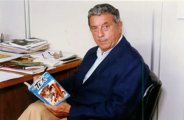 Homem sentado em uma cadeira lendo um gibi