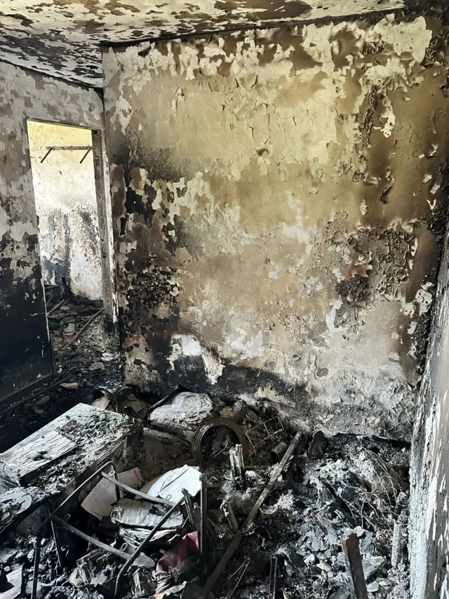 宏新阁的居民黄先生屋内烧毁情况严重，墙身及天花已被烧至熏黑剥落，现场布满灰烬。