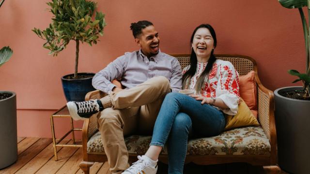 Casal rindo em sofá