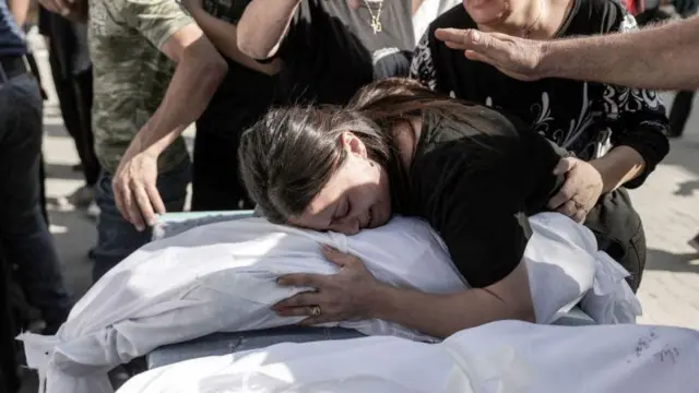 Perempuan memeluk kain berisi jenazah korban pengeboman yang tewas
