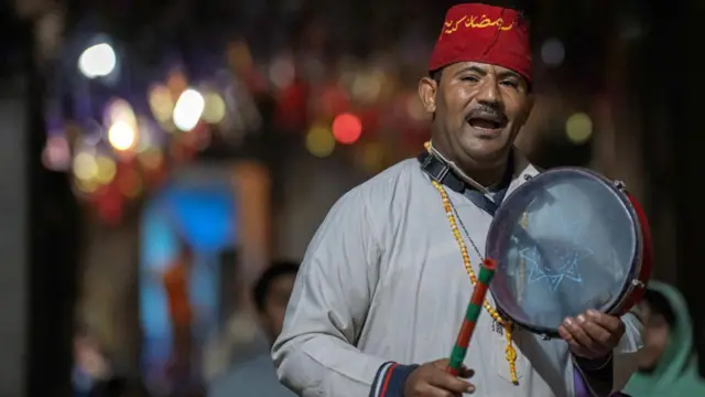 مسحراتي مصري، في أحد احياء القاهرة القديمة، يدعو النائمين للاستيقاظ وتناول وجبة السحور (مارس/آذار 2025)