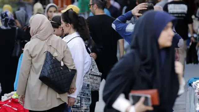 زنان ایرانی، برخی بدون حجاب اجباری، در خیابانی در تهران، ایران، ۱۳ سپتامبر ۲۰۲۳ راه می‌روند.