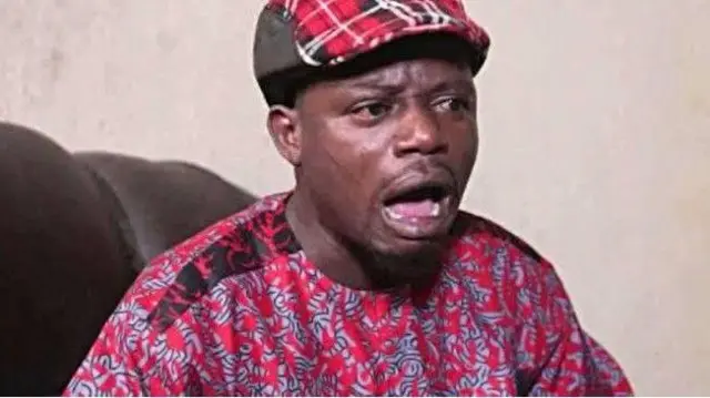 Okele wọ asọ ankara pupa, o de fila bẹntigọ, to si la ẹnu silẹ