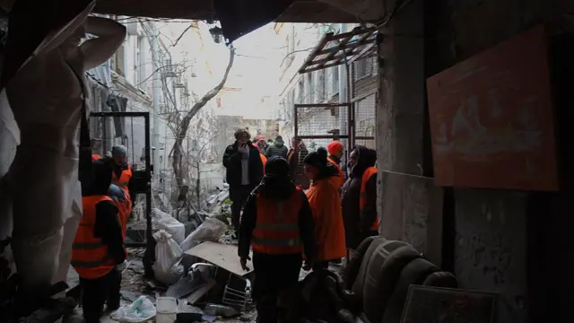 Коммунальщики убирают завалы во дворе поврежденных зданий после обстрела в Одессе 13 декабря 2025 года