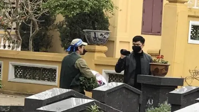 Một số thanh niên mặc thường phục, cầm máy quay dí sát vào mặt những người dân đi thắp hương tại nghĩa trang liệt sỹ thành phố Hà Nội