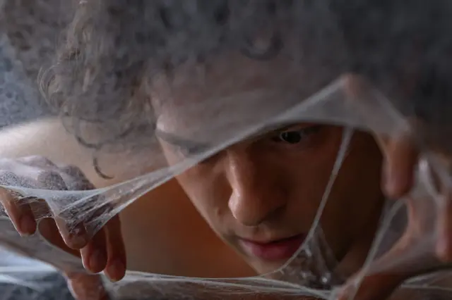 Una imagen promocional de "Spiderman: un nuevo día" muestra al protagonista Tom Holland como Peter Parker desentrañando un telaraña