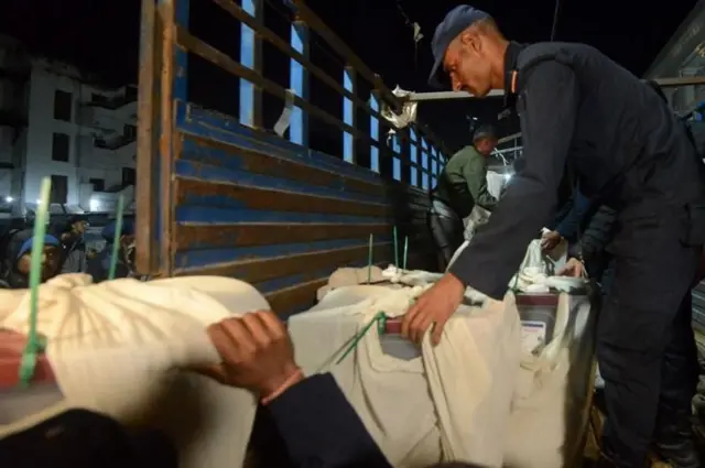 सन् २०२२ मा आम चुनावमा मतदान सम्पन्न भएपछि काठमाण्डूमा सेतो कपडामा पोको पारिएको सील गरिएका मतपेटिका ढुवानीका लागि ट्रकमा जम्मा गरिदैँ। (फाइल तस्बिर)