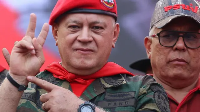 İçişleri Bakanı Diosdado Cabello, kırmızı askeri bere, kırmızı boyun atkısı ve askeri üniforma giyerek bir etkinlikte.