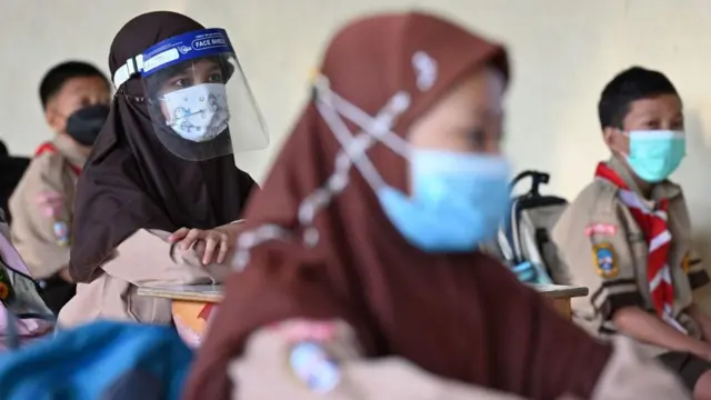 Sejumlah murid sekolah dasar di Jakarta mengikuti penjelasan guru di kelas saat masa pandemi Covid-19, pada September 2021.