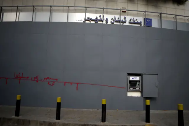 مدخل محصّن لفرع مصرف "لبنان والمهجر" في بيروت، تظهر عليه كتابات غرافيتي وفتحة صراف آلي مفتوحة أمام الزبائن، في صورة التُقطت عام 2020 خلال ذروة الأزمة المالية في لبنان.