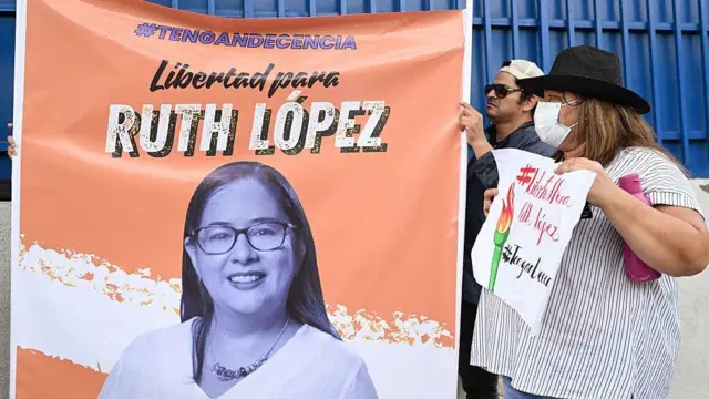 Manifestantes penduram cartaz pedindo a libertação da ativista Ruth López