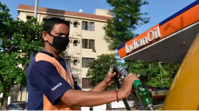 Un pompiste dans une station d'essence en Inde