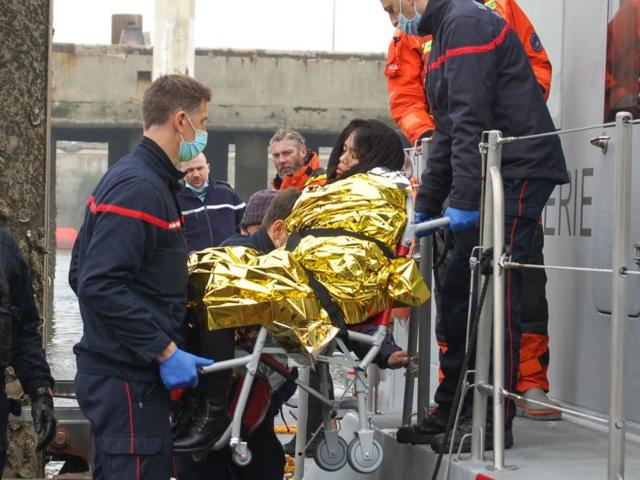 Một phụ nữ Việt Nam mang thai được cáng đi khi chiếc thuyền chở bà cùng 60 người khác đang tìm cách vượt eo biển Manche từ thành phố cảng Calais của Pháp để đến Anh vào ngày 1/4/2021 