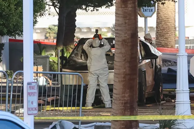 Un investigador vestigo de en traje protector blanco toma una foto del Cybertruck incenciado en Las Vegas