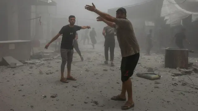 فلسطينيون يتفاعلون أثناء تفقدهم الأضرار في موقع غارة إسرائيلية على منزل في مدينة غزة.