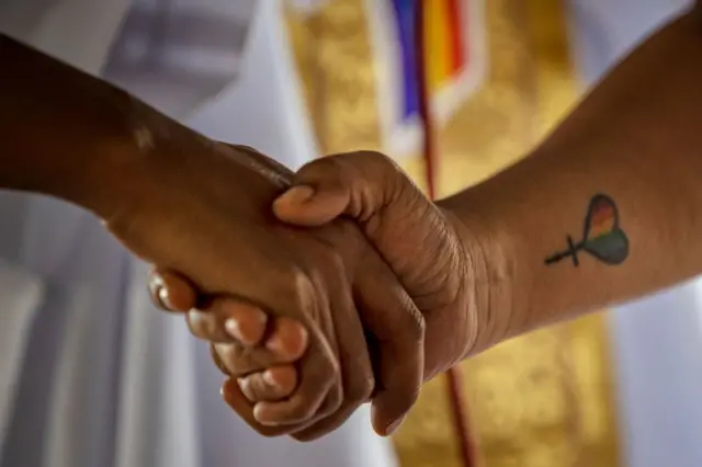 A Filipino same-sex couple hold hands as they tie the knot in a mass wedding ceremony on June 25, 2023 in Quezon city, Metro Manila, Philippines