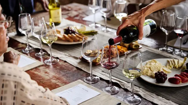 खाने के साथ वाइन परोसी जाती हुई