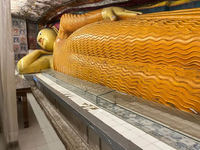 සැතපෙන පිළිමය ඉදිරියේ මල් ආසනය මත සවි කර ඇති පිඟන් ගඩොල්