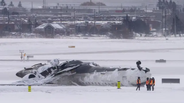 Petugas bandara, memantau, pesawat, mendarat terbalik, Bandara Internasional Pearson Toronto, Februari 2025.