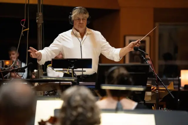 Simon Franglen conducts the orchestra as he records the soundtrack for Avatar: Fire and Ash