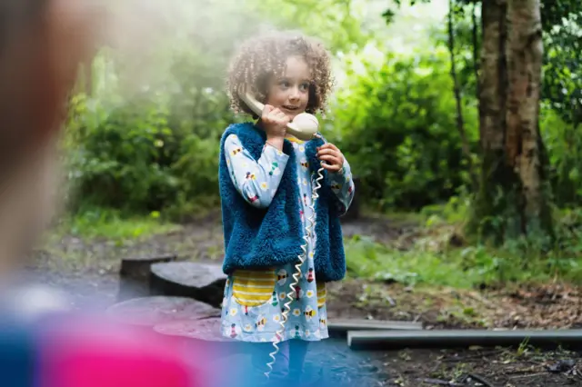 Une fille avec un téléphone jouet