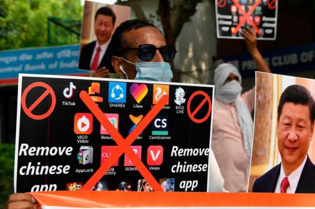 رجل هندي يحمل لافنة كتب عليها" أزيلوا التطبيق الصيني " في إشارة إلى تيك توك