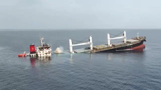 ஒரு பெரிய சரக்கு கப்பல் பாதி மூழ்கிய நிலையில் காணப்படுகிறது