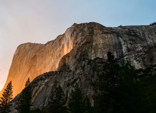 Vista de El Capitán en febrero, durante el fenómeno conocido como "cascada de fuego": cuando el sol golpea una cascada que cae en lo alto de la pared y pareciera que estuviera escupiendo lava.