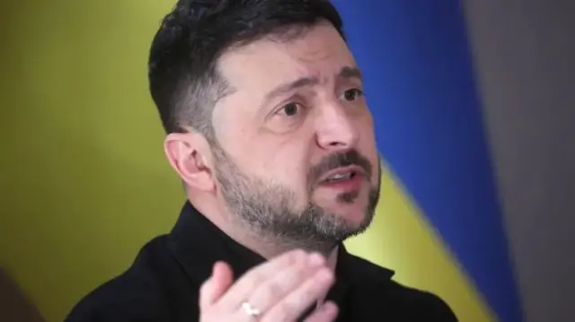 Prezident Vladimir Zelenskiy peshonasini tirishtirib o'ng qo'lini ko'tarib gapiryapti