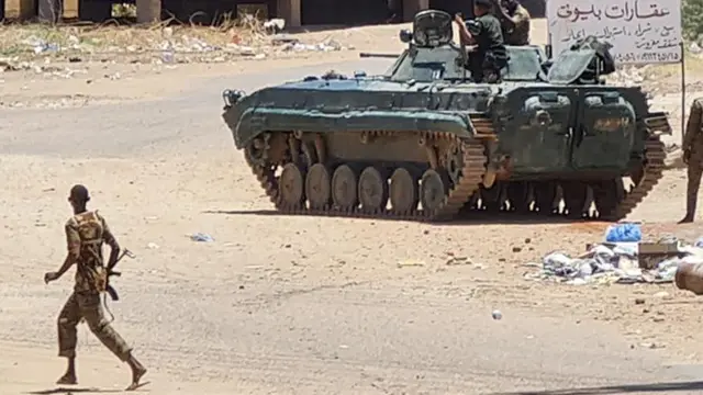 Sebuah tank di Khartoum dengan tentara di dekatnya