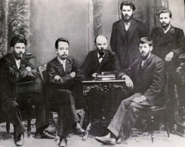 Lênin (sentado no meio) junto a outros revolucionários russos. Entre eles, Yuli Martov (sentado à direita), que se tornou líder dos mencheviques 