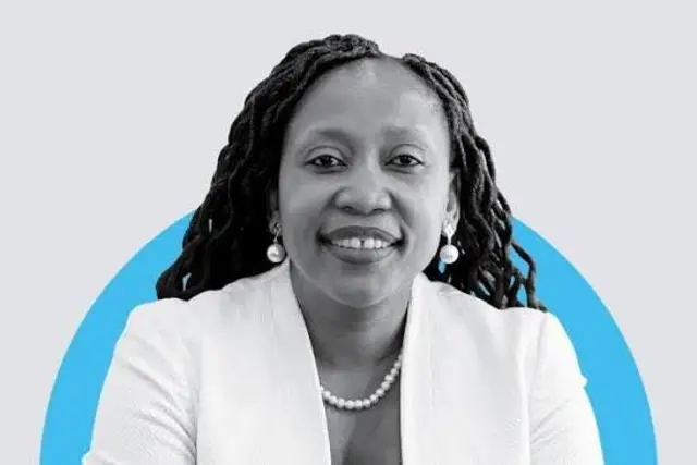 Mpumi Madisa porte une veste blanche, elle sourit à la caméra.