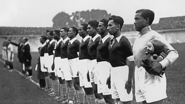 لاعبو منتخب الهند الشرقية الهولندية في نهائيات كأس العالم 1938 يصطفون وقوفاً جانب بعضهم البعض