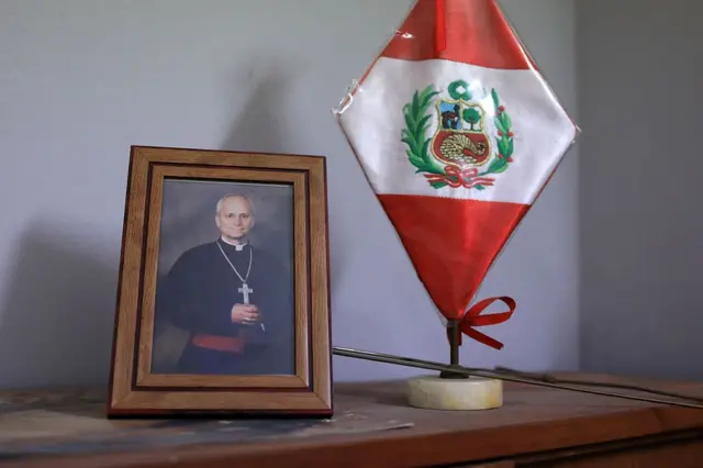 Un retrato del cardenal Prevost en una mesa de la Diócesis de Callao junto a una bandera de Perú.