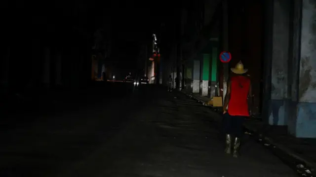 Темная улица с одиноким прохожим на Кубе