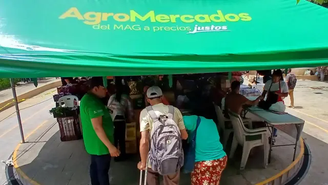 Dos clientes con un "guía" en el agromercado de Apopa, El Salvador, el 9 de septiembre de 2024.