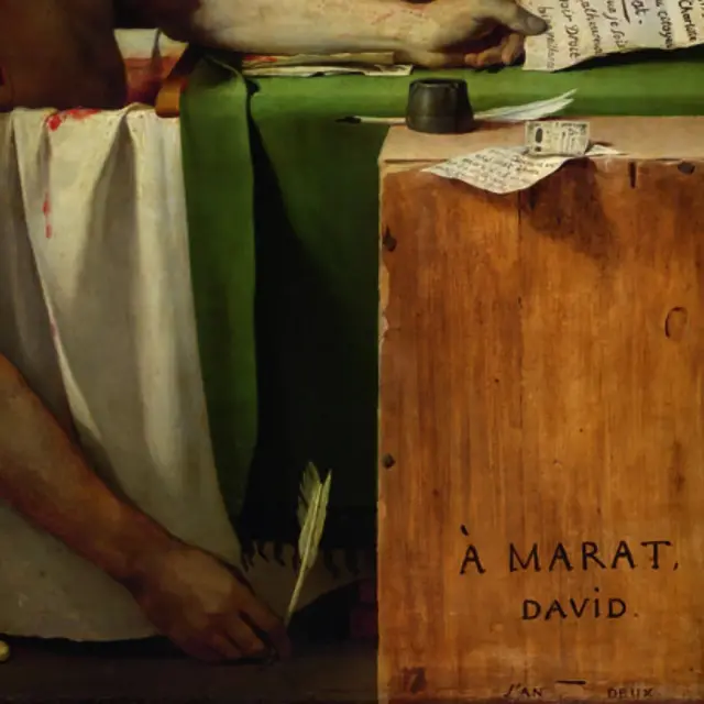 Un acercamiento a la mano del hombre muerto en la bañera en la que sostiene la pluma.