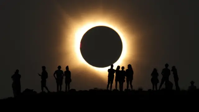 Siluete ljudi iznad njih potpuno pomračenje Sunca