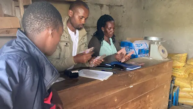Feza afashwa n'umugabo we (uri hagati) mu bucuruzi